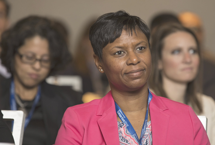 Woman in crowd watching presentation during a conference
